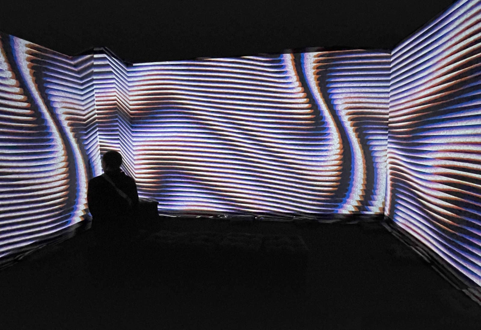 Audience member sitting across ilithya's projection at Affenfaust Galerie in Hamburg