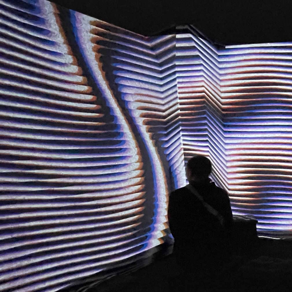 Audience member sitting across ilithya's projection at Affenfaust Galerie in Hamburg